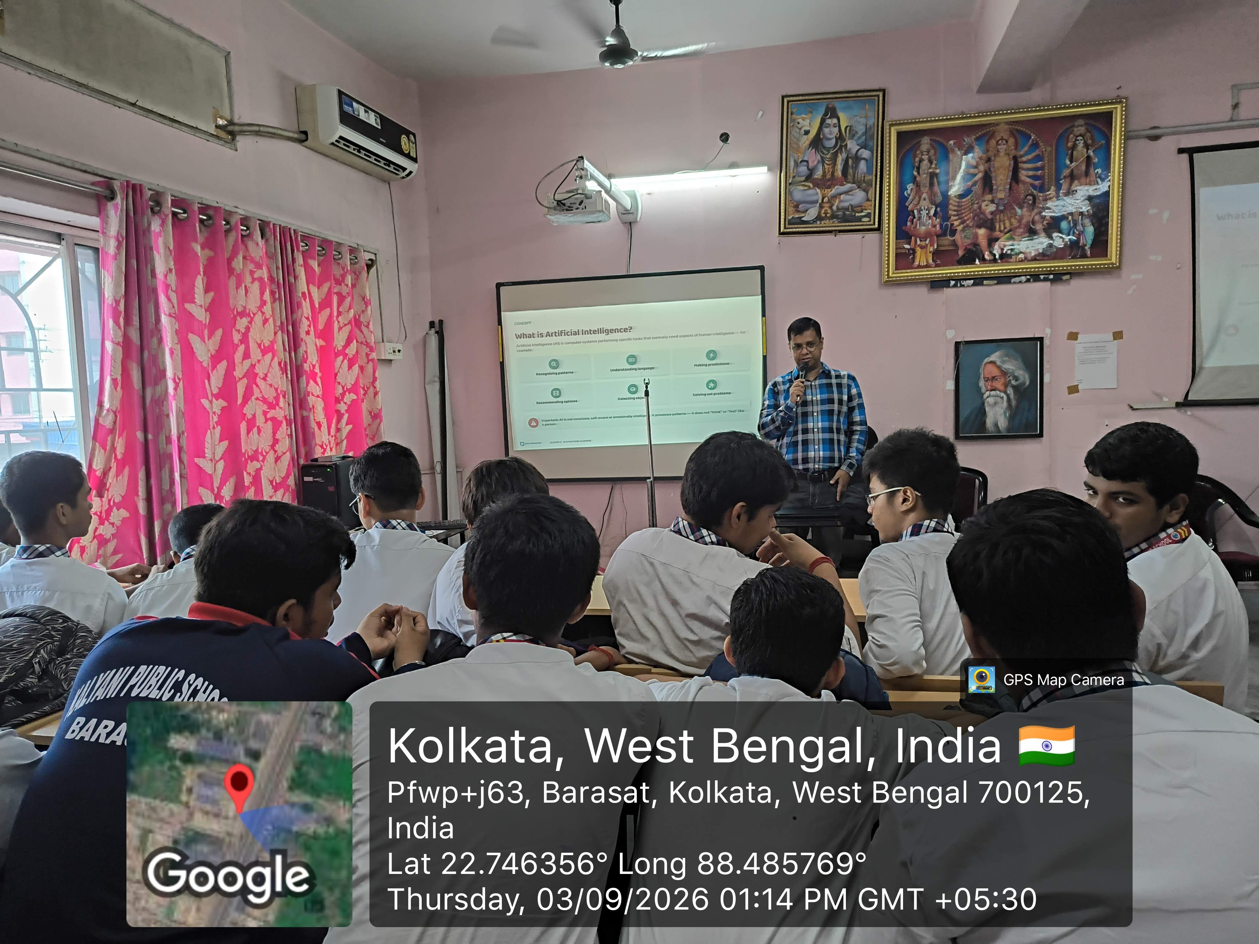 MAVI Foundation presenter walking students through data science fundamentals beside the projector screen at Kalyani Public School, Barasat, 2026 (photo 2 of 16)