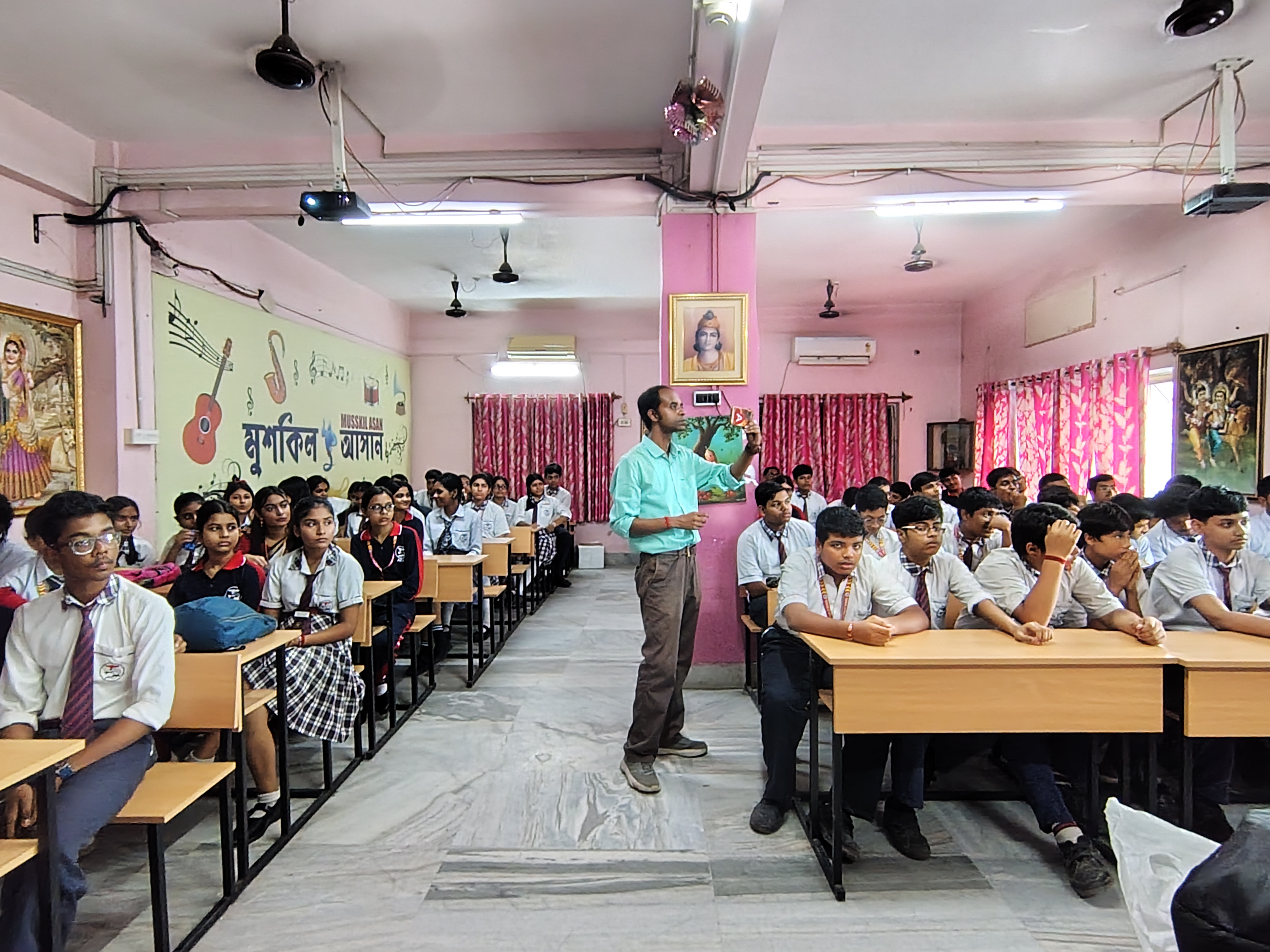 MAVI Foundation presenter taking questions from the aisle among the desks at Kalyani Public School, Barasat, 2026 (photo 4 of 16)