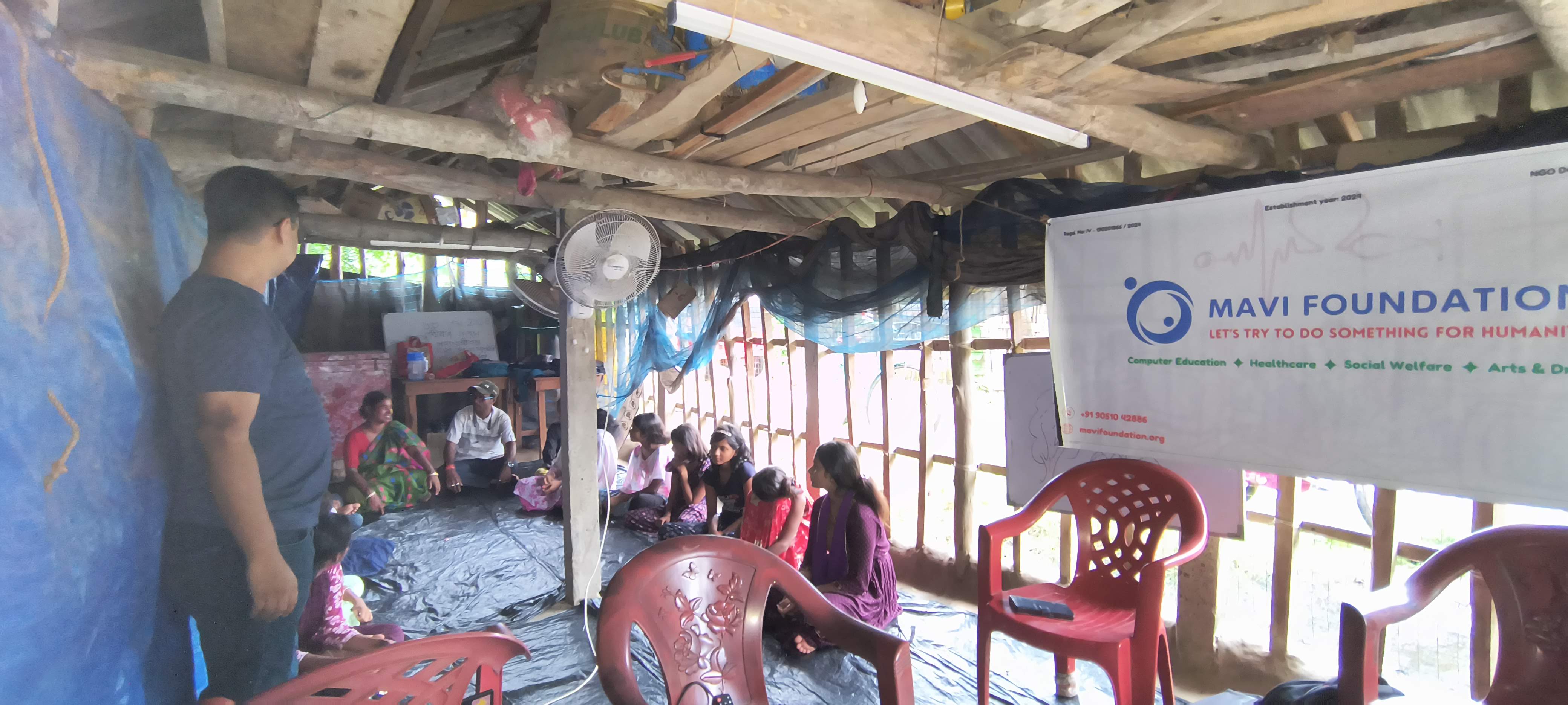 MAVI Foundation banner hanging in the bamboo-and-tin pathsala hut during the free Information Security workshop in Gosaba Block, Sundarbans, 2026 (photo 1 of 8)